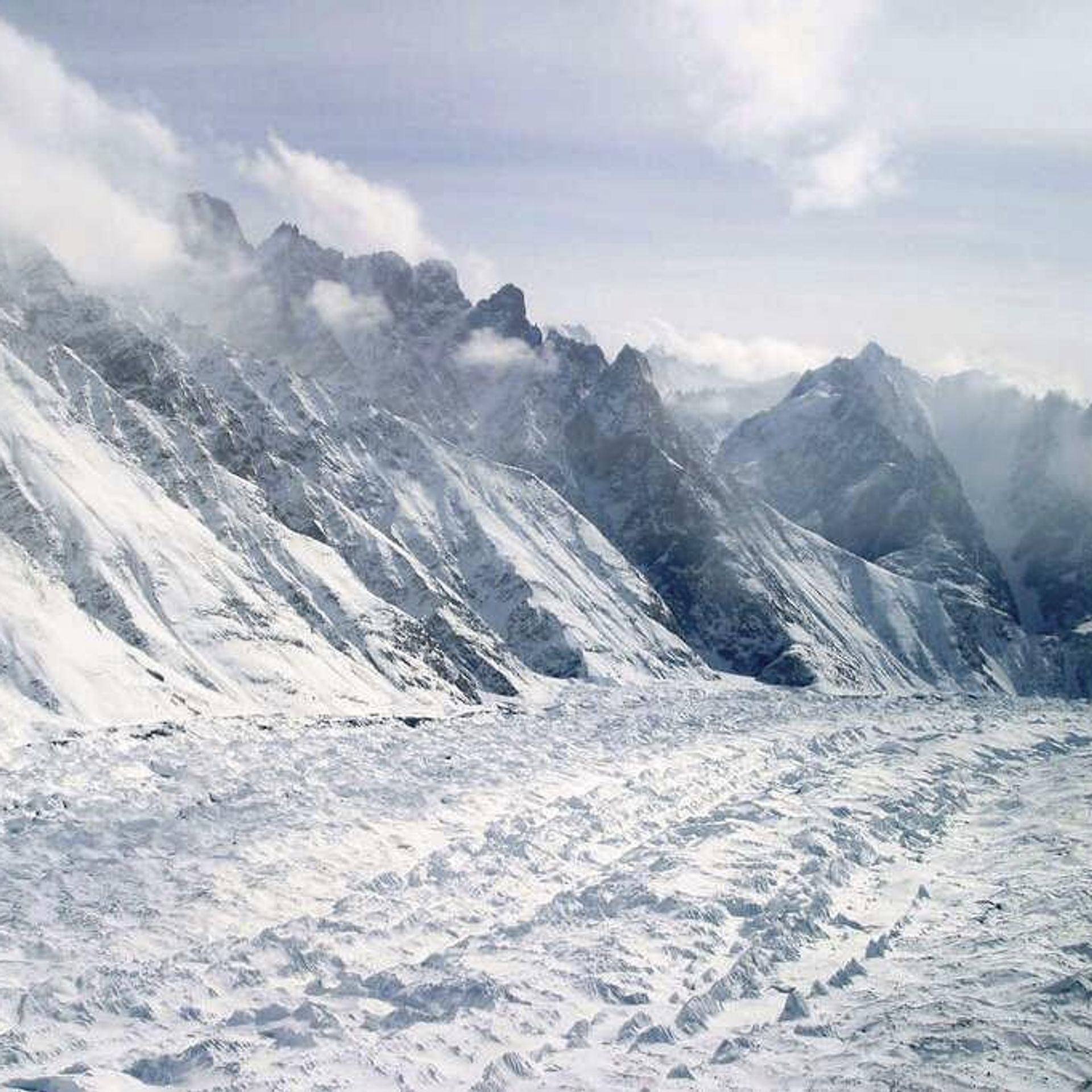 Snow-covered high peaks above a glacier